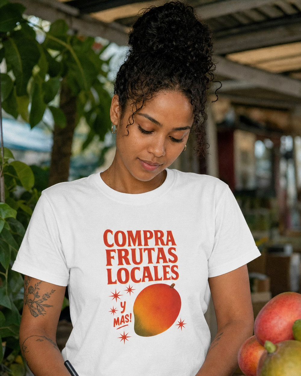 Puerto Rican adult wearing Compra Frutas Locales y Más! in a relaxed creative setting