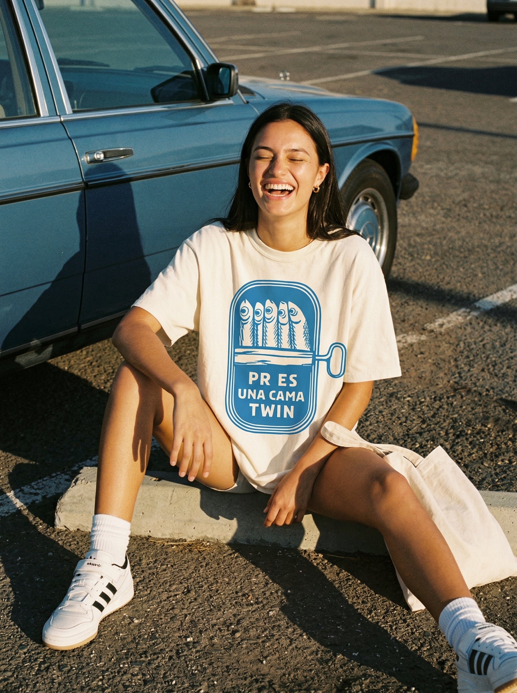 Sardine Can Humor T-Shirt — sardine-can-humor-t-shirt-lifestyle-a-seated-curb-laugh
