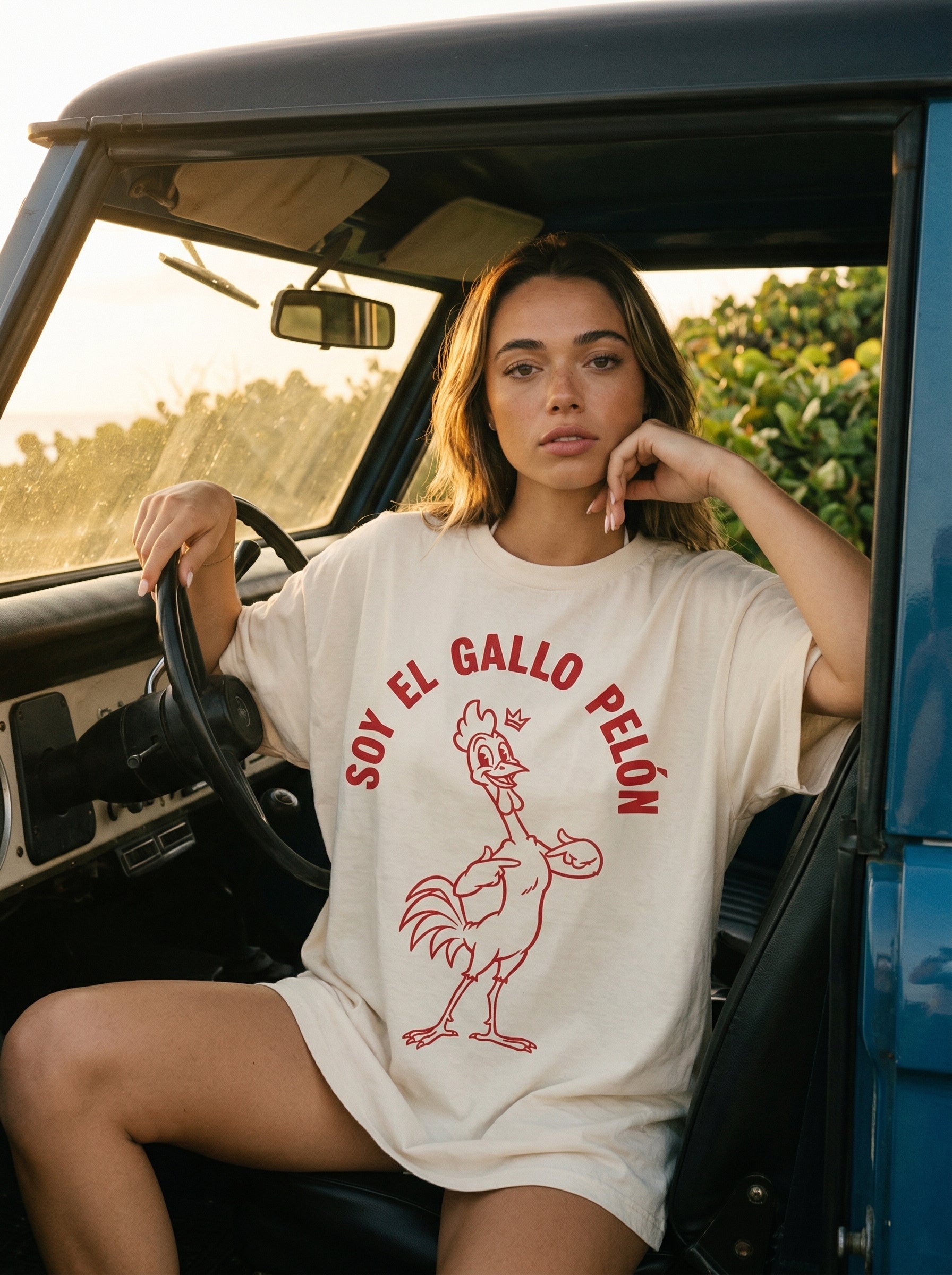 Soy El Gallo Pelón T-Shirt — soy-el-gallo-pel-n-t-shirt-lifestyle-b-in-car-golden-hour